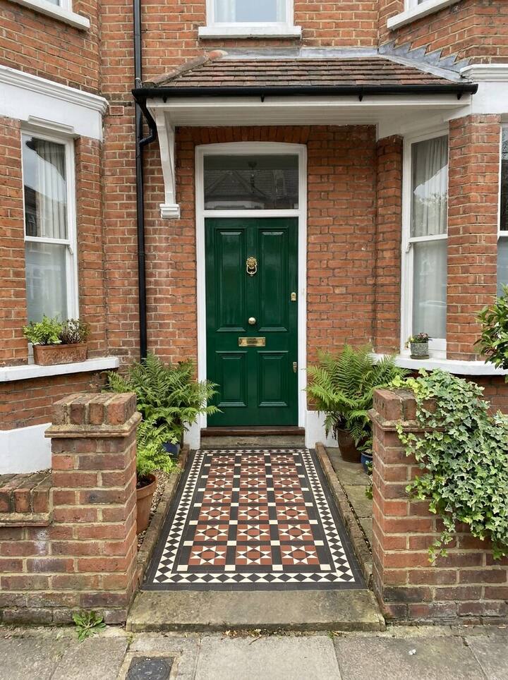 A green front door with a tiled path, with a Nowmark stamp in the corner showing the time, date, address, coordinates and a note.